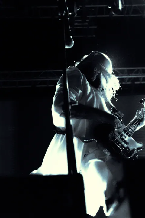 Guitarrista capturado en blanco y negro sobre el escenario.